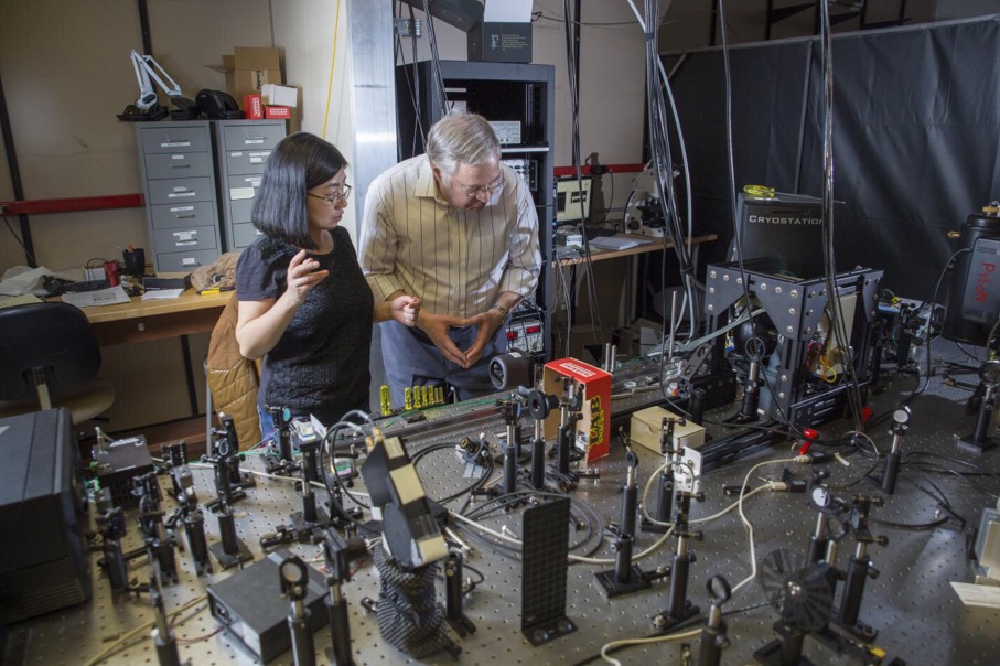 Sarah Li (left) and Z. Valy Vardeny (right) of the Department of Physics & Astronomy at the University of Utah discuss the ultrafast laser used to prepare and measure the direction of the electron spin of hybrid perovskite methyl-ammonium lead iodine (CH3NH3PbI3). They are the first to show that organic-inorganic hybrid perovskites are a promising material class for spintronics, an emerging field that uses the spin of the electron to carry information, rather than the electronic charge used in traditional electronics.
