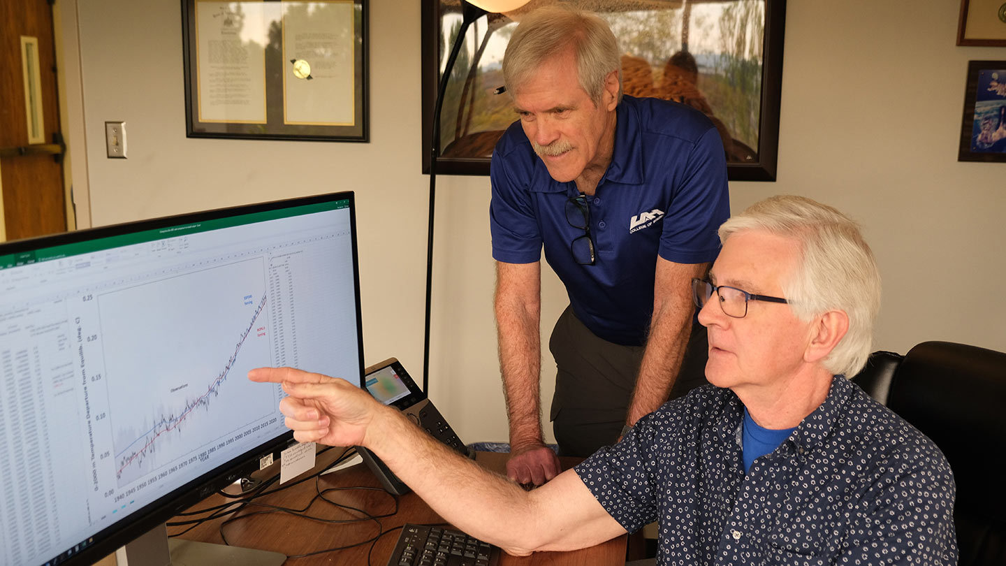 (Left to Right): UAH’s Dr. John Christy reviews results from the one-dimensional climate model Dr. Roy W. Spencer developed.