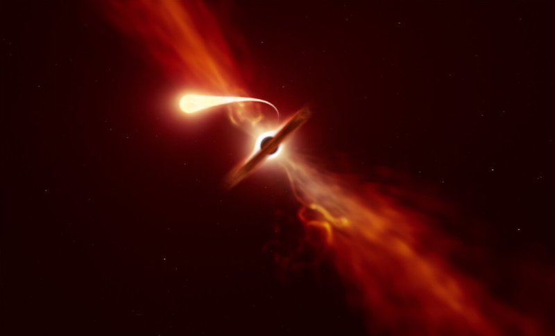 This illustration depicts a star (in the foreground) experiencing spaghettification as it’s sucked in by a supermassive black hole (in the background) during a ‘tidal disruption event’. Credit: ESO/M. Kornmesser
