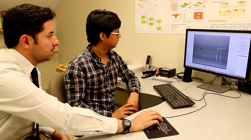 Mohammad R. Jahanshahi, left, an assistant professor in Purdue’s Lyles School of Civil Engineering, and doctoral student Fu-Chen Chen review results using the new system. (Purdue University image/Erin Easterling)