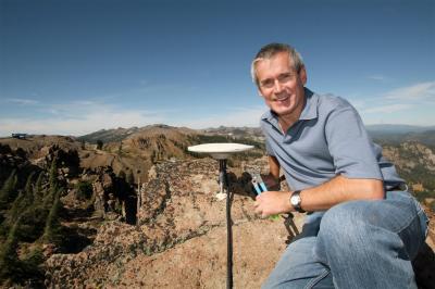 Geoff Blewitt, professor in the University's Nevada Bureau of Mines and Geology and director of the Nevada Geodetic Laboratory, works on a GPS installation atop 8,600-foot-elevation Ward Peak at Lake Tahoe. The Nevada Geodetic Laboratory has the largest GPS data-processing center in the world, which processes information from about 10,000 stations around the globe continuously, 24/7. The system will be used in a major test this year by NASA of a GPS monitoring system for big earthquakes along the West Coast of the United States.  Credit: Photo by Jean Dixon, courtesy of University of Nevada, Reno.