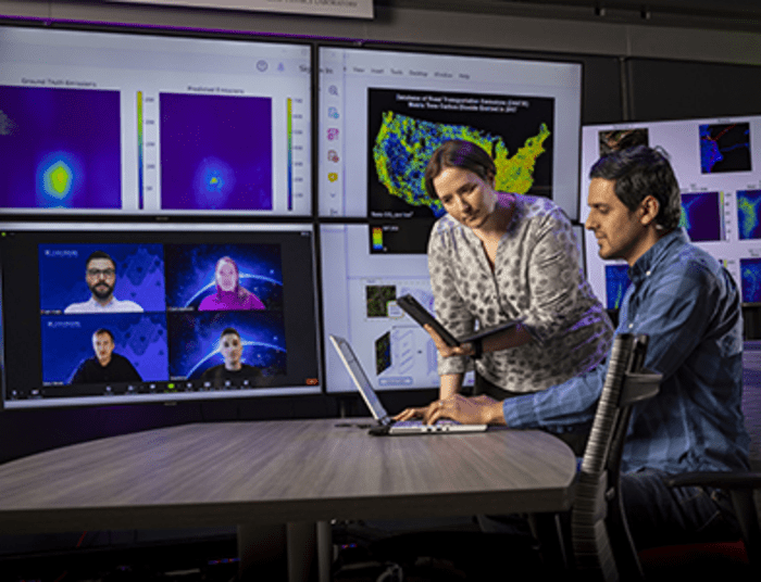 Marisa Hughes (center) works with a team that includes experts in machine learning, remote sensing and computer vision to leverage artificial intelligence to produce accurate estimates for road transportation emissions of the top 500 emitting cities worldwide.  CREDIT JHU/APL, Ed Whitman