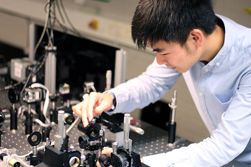 Photo (Paderborn University, Thomas Zentgraf): Jinlong Lu taking measurements in the optics lab.