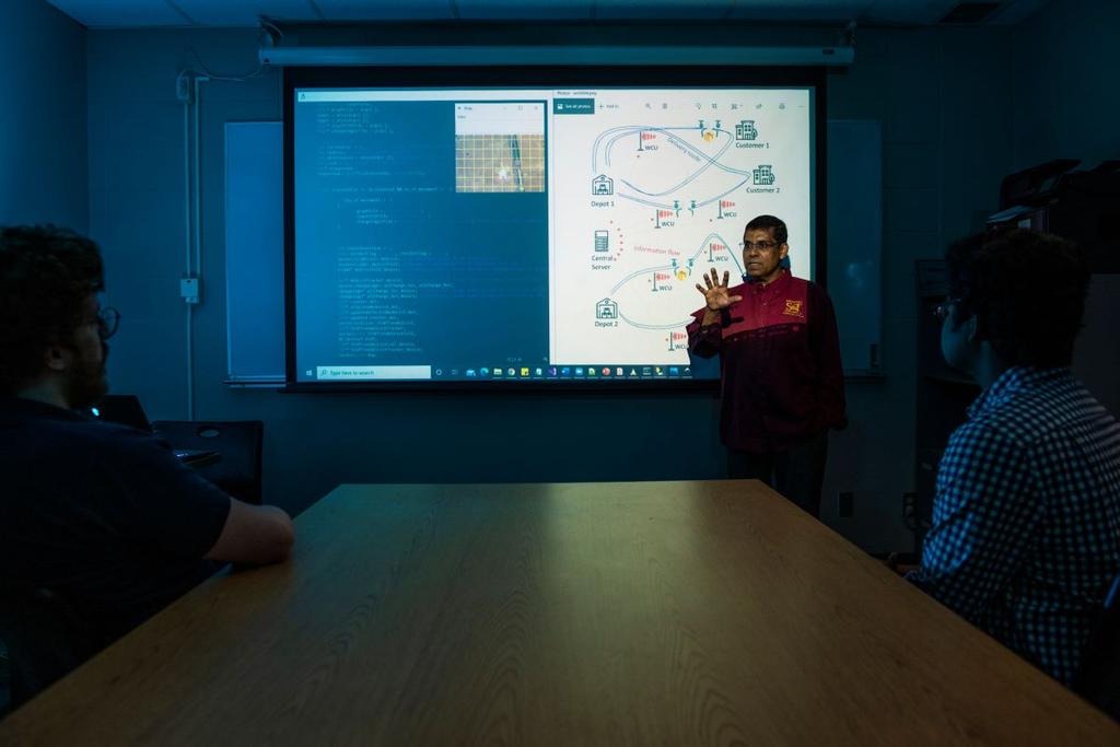 Dr. Sajal Das reviews work by Missouri S&T computer science graduate students on the Cyberinfrastructure for Accelerating Innovation in Network Dynamics (CANDY) project. Photo by Michael Pierce, Missouri S&T.