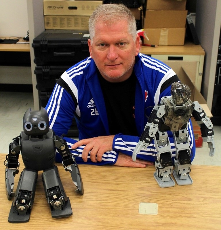 Eric Matson, Purdue University associate professor of computer and information technology, with a couple friends (small, commercially available programmable robots that he uses in his robotics class and research.) Matson's research focuses on the intersection of technologies such as robotics, artificial intelligence and sensor networks and he’s involved in developing firefighting robots and robots to assist senior citizens in living independently. 