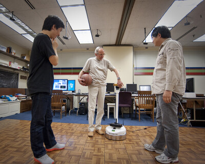 Zygmunt Pizlo, Purdue professor in the Department of Psychological Sciences, stands between postdoctoral research assistants Tadamasa Sawada and Yunfeng Li, as he adjusts the vision of a robot named Capek. The researchers will move around the dance floor in Pizlo’s laboratory while the robot 